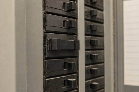 Row of breaker handles inside a panel with one double-pole handle sitting between the on and off positions