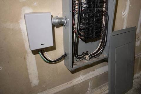 Small surge device mounted to the side of a load center through a short conduit nipple, leads entering the enclosure