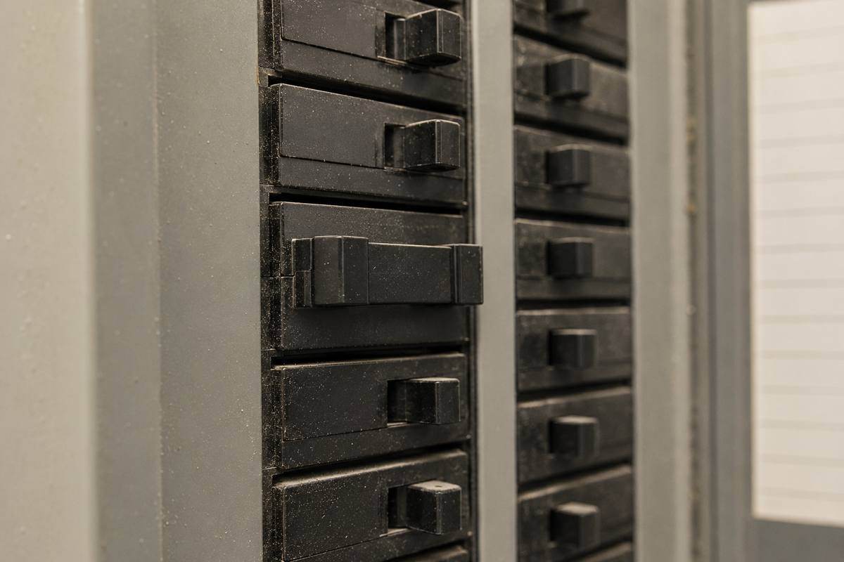 Row of breaker handles inside a panel with one double-pole handle sitting between the on and off positions